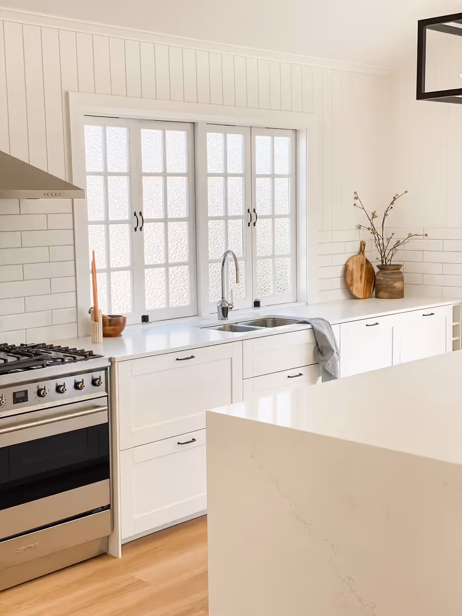 Galley kitchen with a freestanding cooker, subway tiles and a waterfall stone island