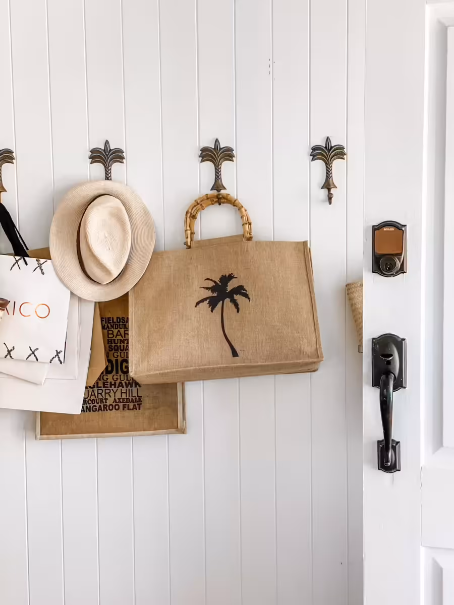 Woven bags and a straw hat hung on palm-tree hooks beside the front door