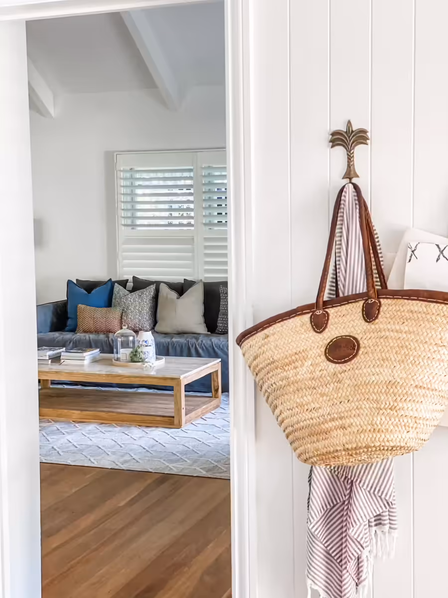 View from the entry through to the living room, a basket bag hanging on a palm hook