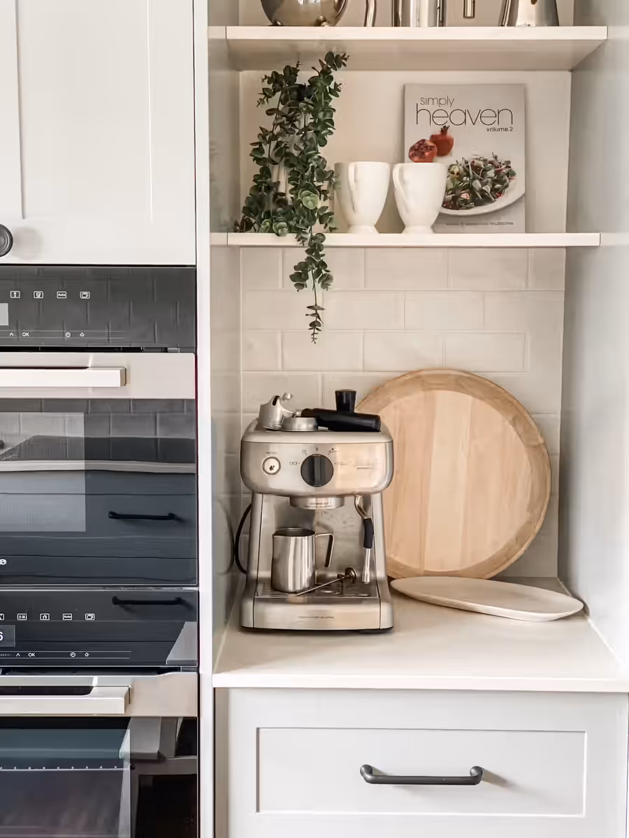 Coffee machine and timber boards on the benchtop beside the wall oven