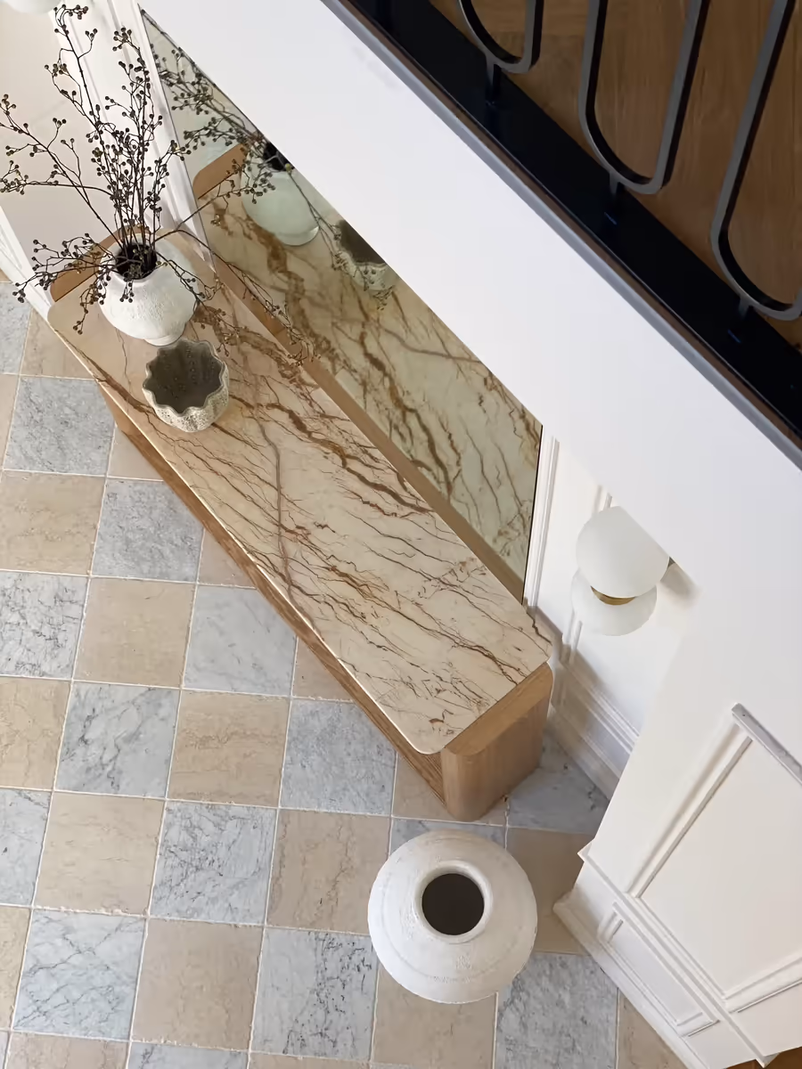 Looking down on the marble console and checkerboard tiles beneath the staircase