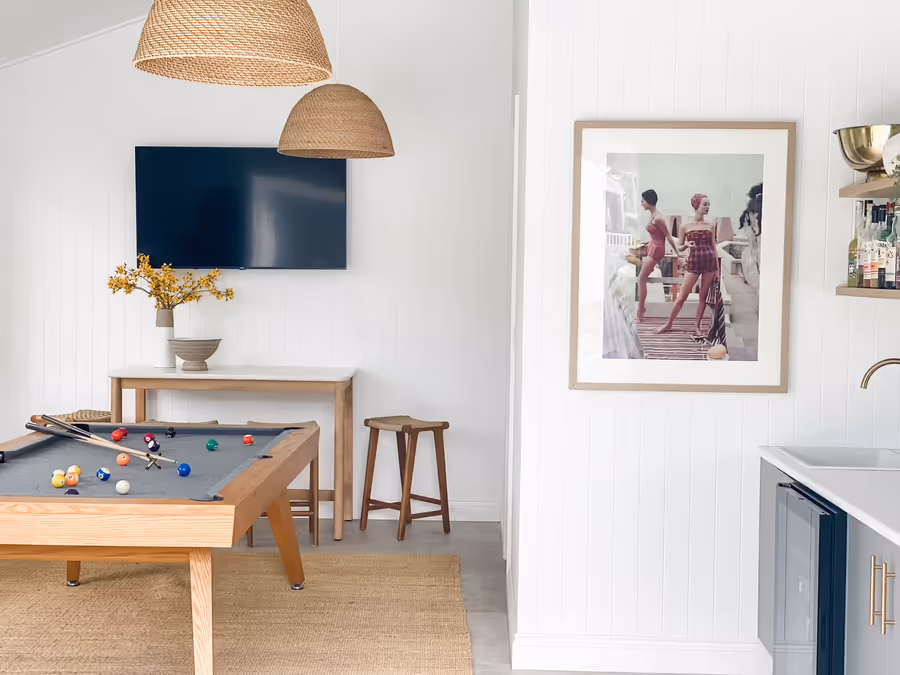Rumpus room with a pool table and rattan pendants, beside a framed print