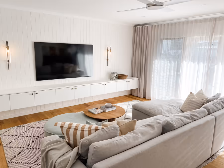 Living room with the linen corner sofa and sage ottoman on a checked rug