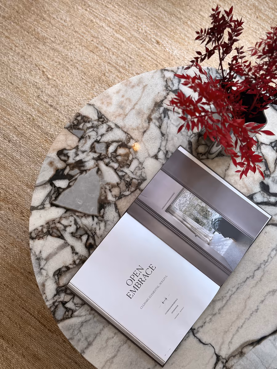 Open book and red foliage on the round Calacatta Viola side table