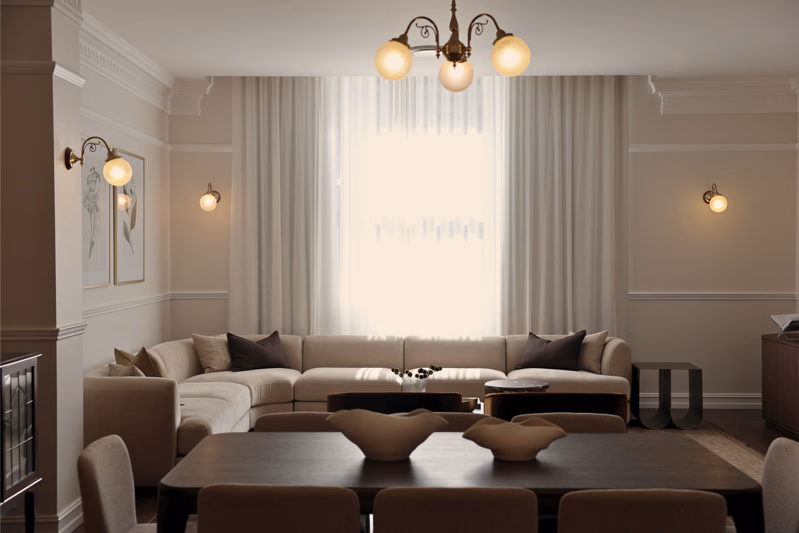 Living and dining room under the brass chandelier, sheers drawn across the window