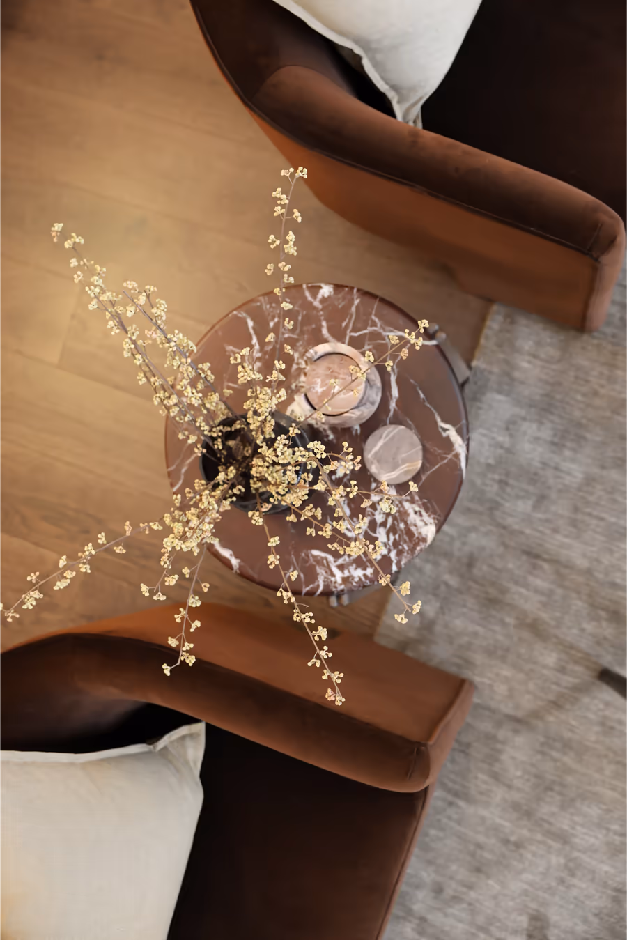 Looking down on a marble side table set between rust velvet armchairs