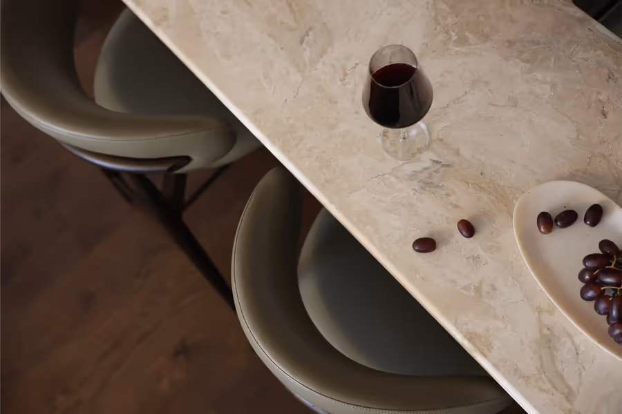 Wine glass and olives on the stone island, olive leather stools pulled up