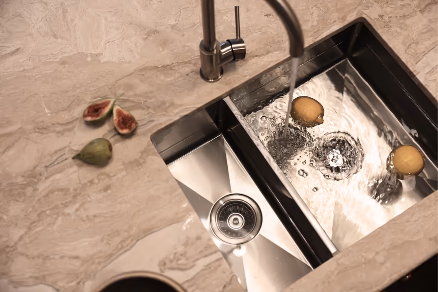 Figs beside the stainless sink set into the veined stone benchtop