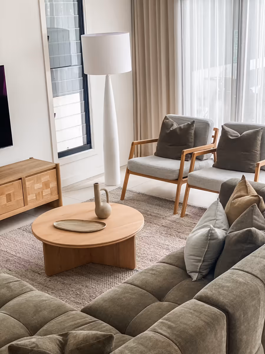 Olive tufted sofa and timber armchairs around a round oak coffee table
